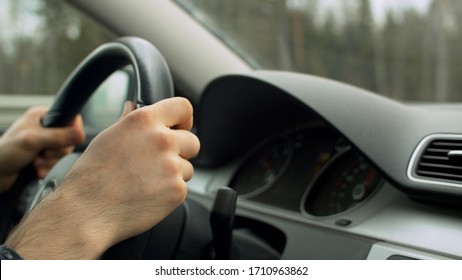 Close Up Man's Hands On The Steering Wheel Of Moving Car. Driver's Point Of View, POV. Dashboard