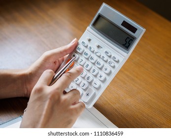 Close up of man's hands is using calculator on wooden desktop. business, Education concept.