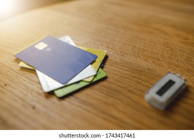 Close up many credit cards and code generator on a wooden table. Home banking for internet payments. Debts and technology concept.