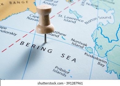 Close Up Of  Map With The Words Bering Sea In Focus With A Push Pin Marking The Spot