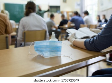 Close up of mask and disinfectant on school desk beside student with gloves after pandemic. Safety and recommended measures - Powered by Shutterstock