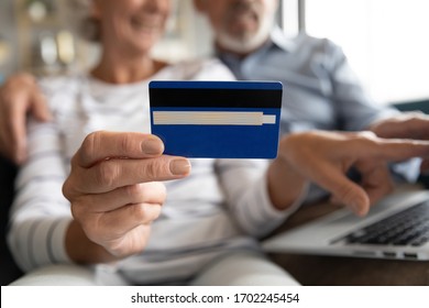 Close Up Mature Couple Paying Online, Older Female Holding Plastic Credit Card In Fingers, Elderly Man And Woman Using Laptop, Shopping, Booking Hotel, Using Internet Banking Service, Making Payment