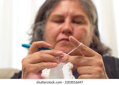 Close Up Of Mature Latina Woman Knitting From Her Home In Her Comfort Zone.