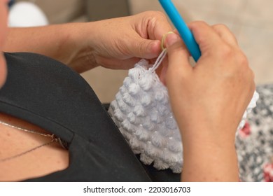 Close Up Of Mature Latina Woman Knitting From Her Home In Her Comfort Zone.