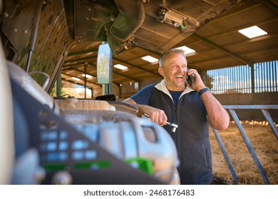 Close Up Of Mature Male Farm Worker On Phone Trying To Fix Machinery - Powered by Shutterstock