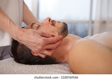 Close Up Of Mature Man Getting Face And Neck Massage At Spa Center