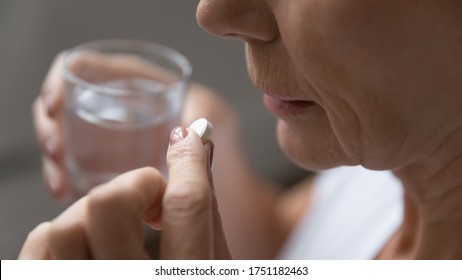 Close Up Of Mature Sick Woman Having Antibiotic Aspirin Pill Suffering From Headache Or Migraine, Ill Senior Female Take Daily Dose Of Vitamin Or Supplement, Medications, Elderly Healthcare Concept