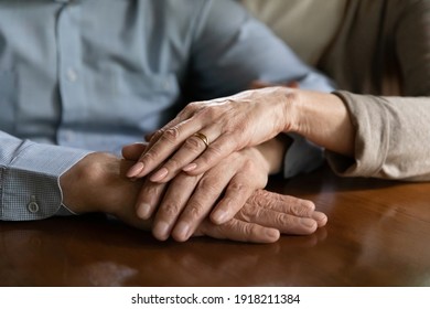 Close up mature spouses holding hands, enjoying tender moment, loving elderly wife supporting comforting husband, expressing empathy and understanding, trusted relationship in marriage concept
