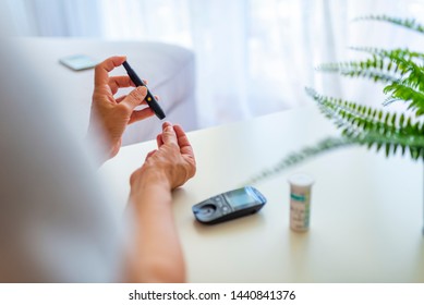 Close Up Of Mature Woman Hands Using Lancet On Finger To Check Blood Sugar Level By Glucose Meter, Healthcare Medical And Check Up, Medicine, Diabetes, Glycemia, Health Care And People Concept