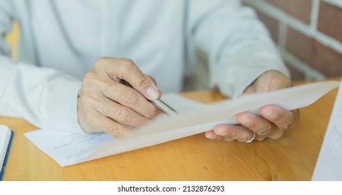 Close Up Mature Woman Hold Invoice Paper To Read And Checklist Of Expense Or Loan From Bank At Home For Cost Of Living Lifestyle Concept