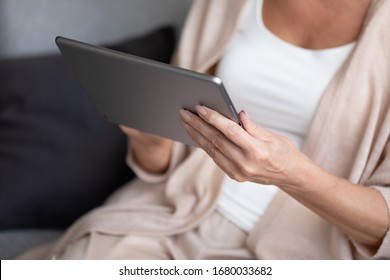 Close Up Mature Woman Holding Digital Tablet. Older Retired Lady Using Computer Applications, Chatting With Friends In Social Networks, Shopping In Internet Store, Reading E-book Or News In Media.
