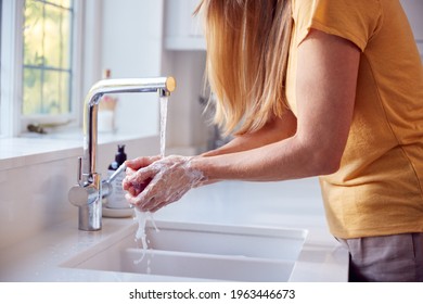 Close Up Of Mature Woman Washing Hands In Kitchen Sink