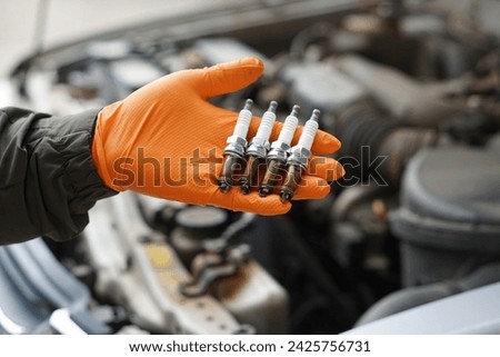 Close up mechanic hands hold old spark plug, spare part of car engine. Concept, machine maintenance, fix, repair, check or diagnose automobile problems by engine specialist.                           