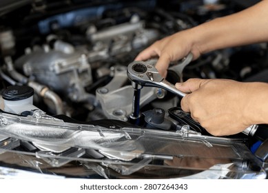 Close up mechanic hands using wrench to replace car engine mount, Automotive maintenance, Worn part replacement according to service manual schedule, Vehicle repair inspection for safety performance