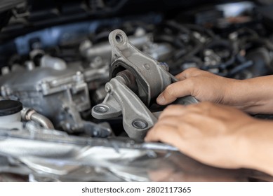 Close up mechanic holding worn engine mount part while inspecting car engine bay, Replacing damaged automotive components according to service schedule, Vehicle maintenance, Safety check optimal