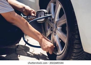 Close up mechanic inflating tire hand holding gauge pressure for checking and filling air in car tire. Automobile concept. - Shutterstock ID 2022685544