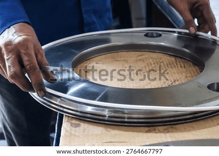 Close up of a mechanic technician hand installing a rubber seal ring onto a large metal automatic transmission piston during assembly in a professional workshop garage.