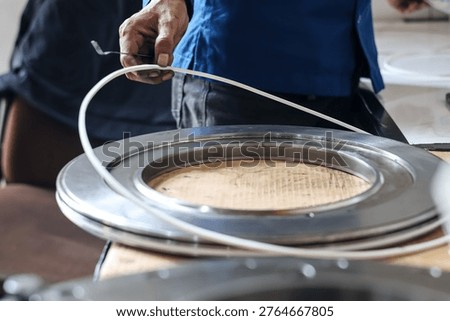 Close up of a mechanic technician hand installing a rubber seal ring onto a large metal automatic transmission piston during assembly in a professional workshop garage.