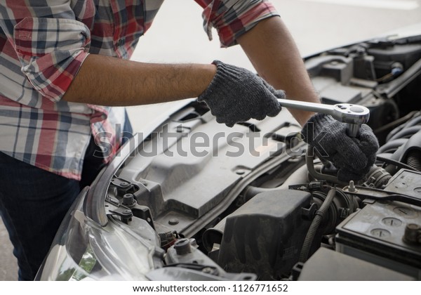 Close up mechanical man dirty\
hands using tool to fix repair car engine, maintenance vehicle\
service. dirty man hands holding tools maintenance car\
concept
