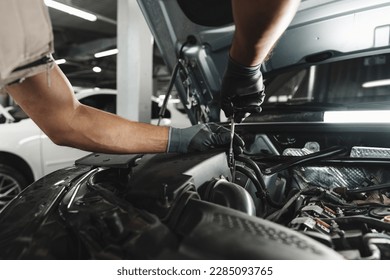 Close up of mechanic's hands repairing car engine in car service - Powered by Shutterstock