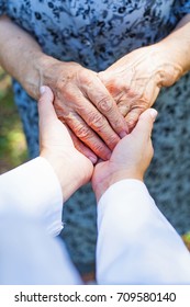 Close Up Medical Doctor Holding Senior Woman's Shaking Hands, Parkinson Disease