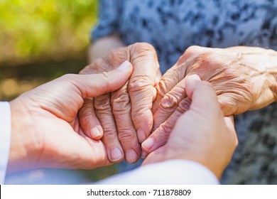 Close Up Medical Doctor Holding Senior Woman's Shaking Hands, Parkinson Disease