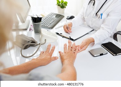  Close Up Of A Medical Examination.Middle Aged Woman With Arthritis Showing Her Hands To A Female Doctor.