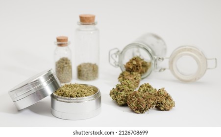 Close Up Of Medical Marijuana Buds , Crusher , Glass Bottles, White Background