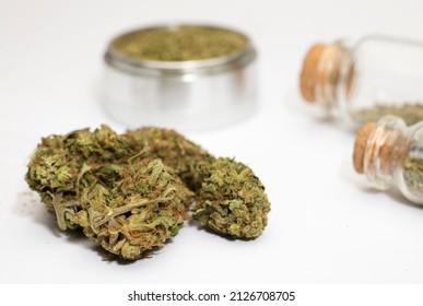 Close Up Of Medical Marijuana Buds , Crusher , Glass Bottles, White Background