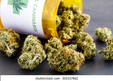 Close Up Of Medical Marijuana Buds Spilling Out Of Prescription Bottle With Label On Black Background