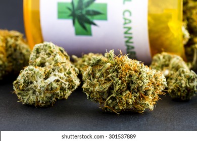 Close Up Of Medical Marijuana Buds Spilling Out Of Prescription Bottle With Label On Black Background