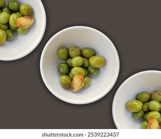 Close up of Mediterranean olives with a garlic clove in a white bowl on a gray background - Powered by Shutterstock