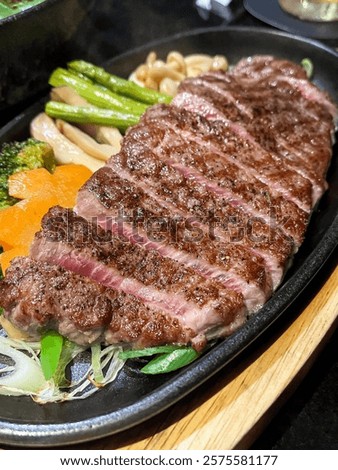 Close up of medium rare rib eye steak with grilled vegetable.