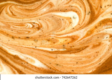 Close up melted mocha or coffee flavored and vanilla ice cream textured background.