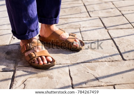 Close up of men food wearing genuine Sandal leather shoes or vintage leather sandal shoe on the concrete road