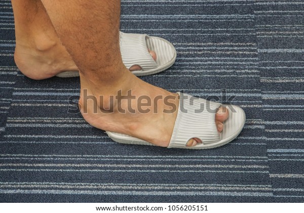 close up men wear too tight sandal on his feet in\
the house