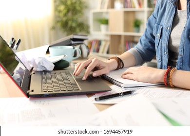 Close Up Of Messy Student Girl Hands Using Laptop At Home On A Disorganized Desk