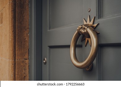 Close Up Of A Metal Door Knocker On A Wooden Front Door Of A House.