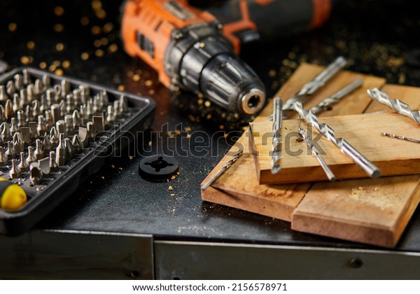 Close up of a metal drill\
bit set at workshop, carpenter chooses a drill for drilling a\
wooden block.