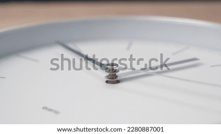 Close up metal hands of white clock go forward. wall clock quickly shows time. Indistinguishable time, focus on center of hands.