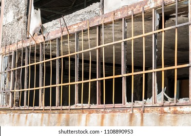 Close Up Of Metal Safety Bars On The Windows Of Small House Damaged Walls With Bullet Holes Used As Improvised Hidden Prison In The War Zone By Terrorists In The Syria, Selective Focus