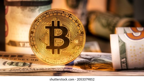Close up of metal shiny bitcoin crypto currency coins on US dollar bills. Electronic decentralized money concept. Bitcoin is convenient payment in global economy market.  - Shutterstock ID 2053379852