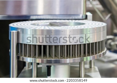 Close up metal stainless steel capsule disc and pin disc on rotary table component of capsule filling machine for industrial