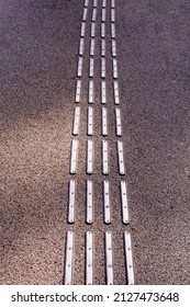 Close up of metallic cat eyes or pavement guidance marker for disabled reflectors textures pattern on asphalt.