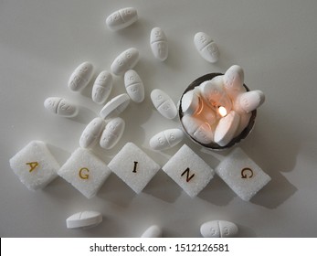 Close Up Of Metformin Drug, Sugar Cubes And Flame. Symbolise Delay Aging And Living Longer. Diabetis Or Diabetic, Part Of A Serie.          