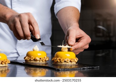 Close up Michelin star pastry chef decorating delicious dessert dish for customers. Garnishing dessert in commercial kitchen.