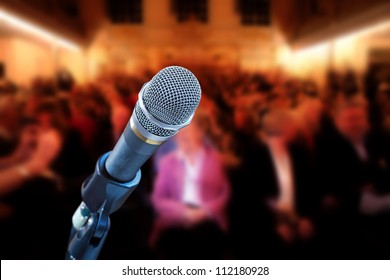 Close Up Of Microphone In Concert Hall, With Audience In Background