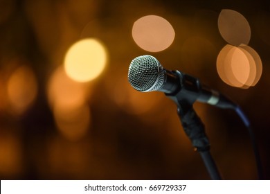 Close up of microphone of a DJ over the abstract blurred background on a big wedding party.