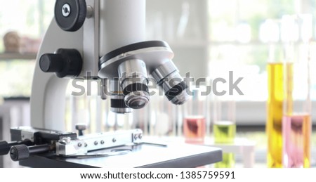 Close up of microscope in laboratory with other instruments like tubes and stack. Concept foe biochemistry science, education studying and learning, lab test and experiment ,scientist research.