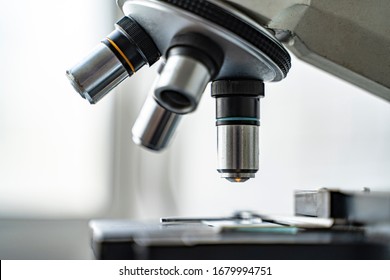 close up microscope stage and objectives researching corona virus microscopic cells behavior testing vaccination cure, in medical center lab china Wuhan world health organization research facilities